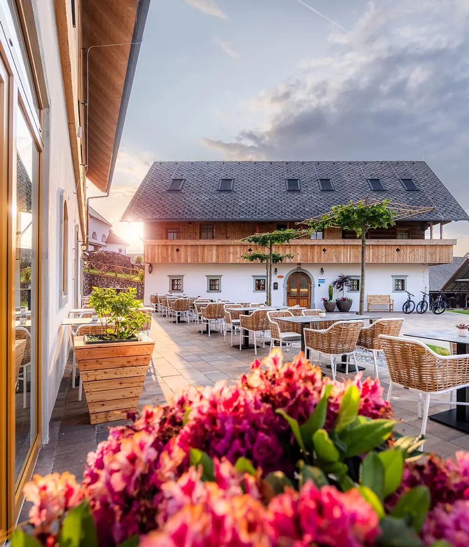 Hotel Julian Alps building and terrace in Zgornje Gorje at sunset